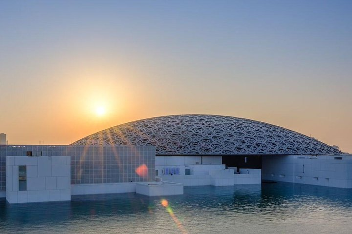 Discover the stunning architecture of Louvre Abu Dhabi where art and civilization collide under a serene sunset offering an immersive journey through history and culture from Dubai.